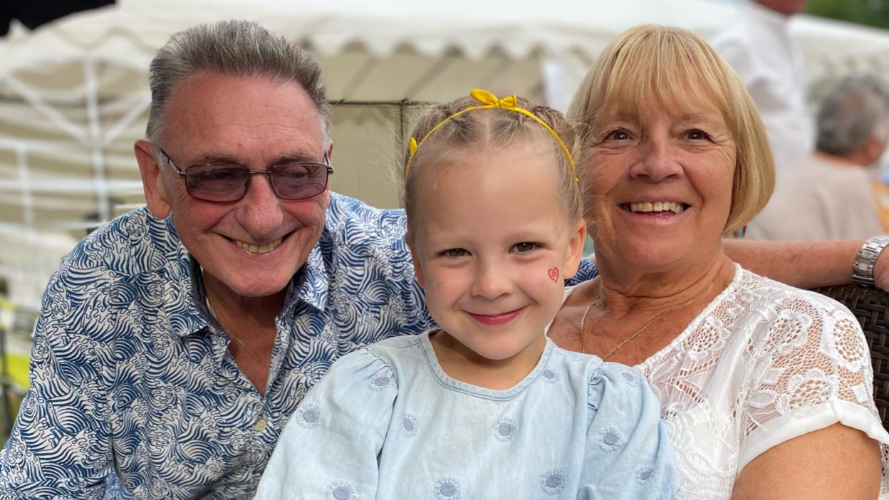 Avril Hackett a'i gŵr gyda'u hwyres Emily yn y canol o'u blaenau