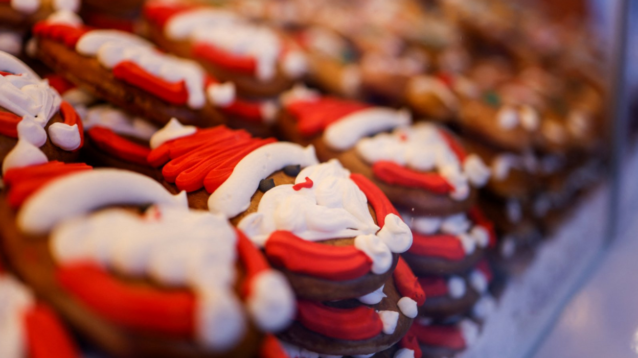 A gingerbread biscuit covered in red and white icing to look like Santa.