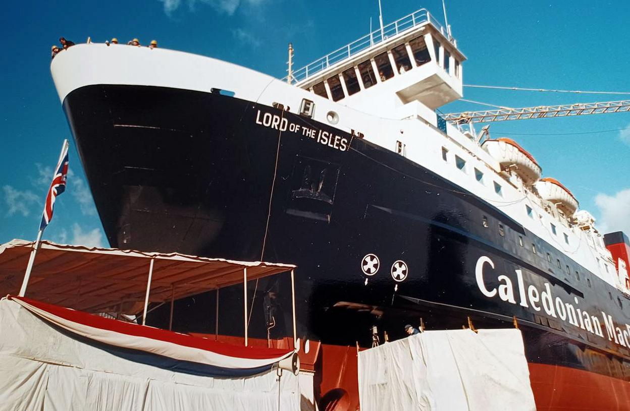 A black and white ship with red paint below the waterline on a slipway waiting to be launched