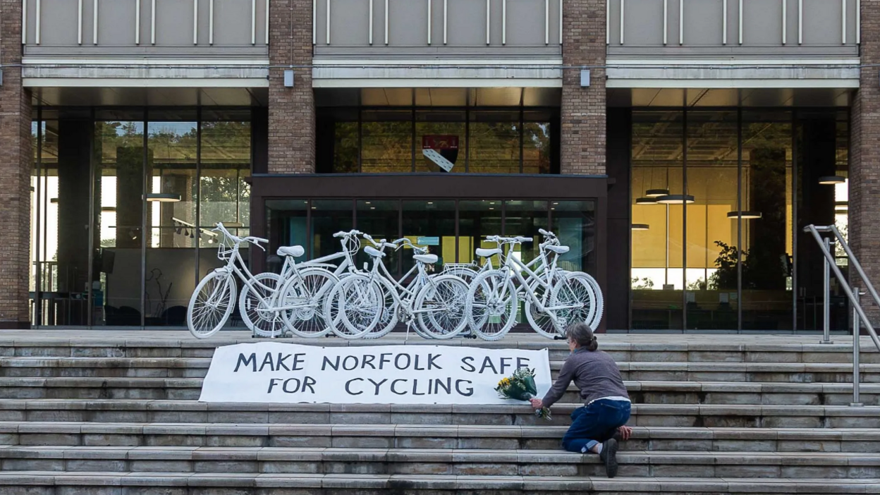 Flowers being laid in front of white bikes