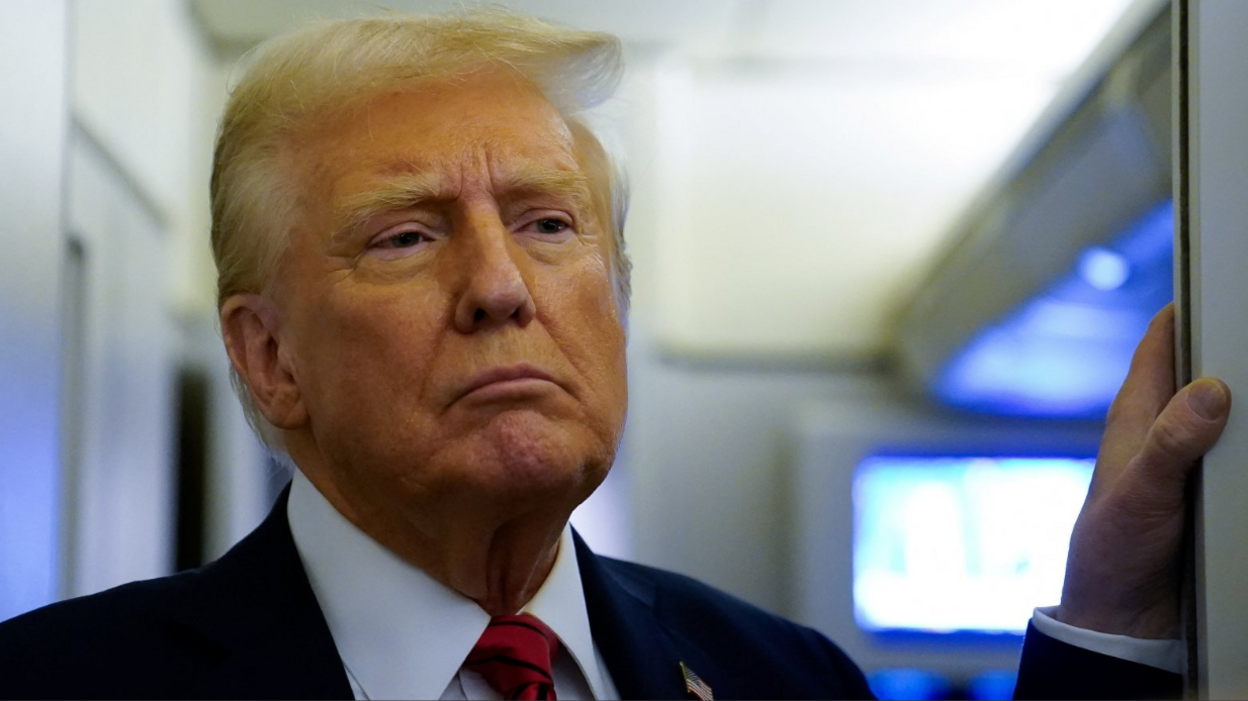 U.S. President Donald Trump speaks to reporters aboard Air Force One before arriving at Joint Base Andrews