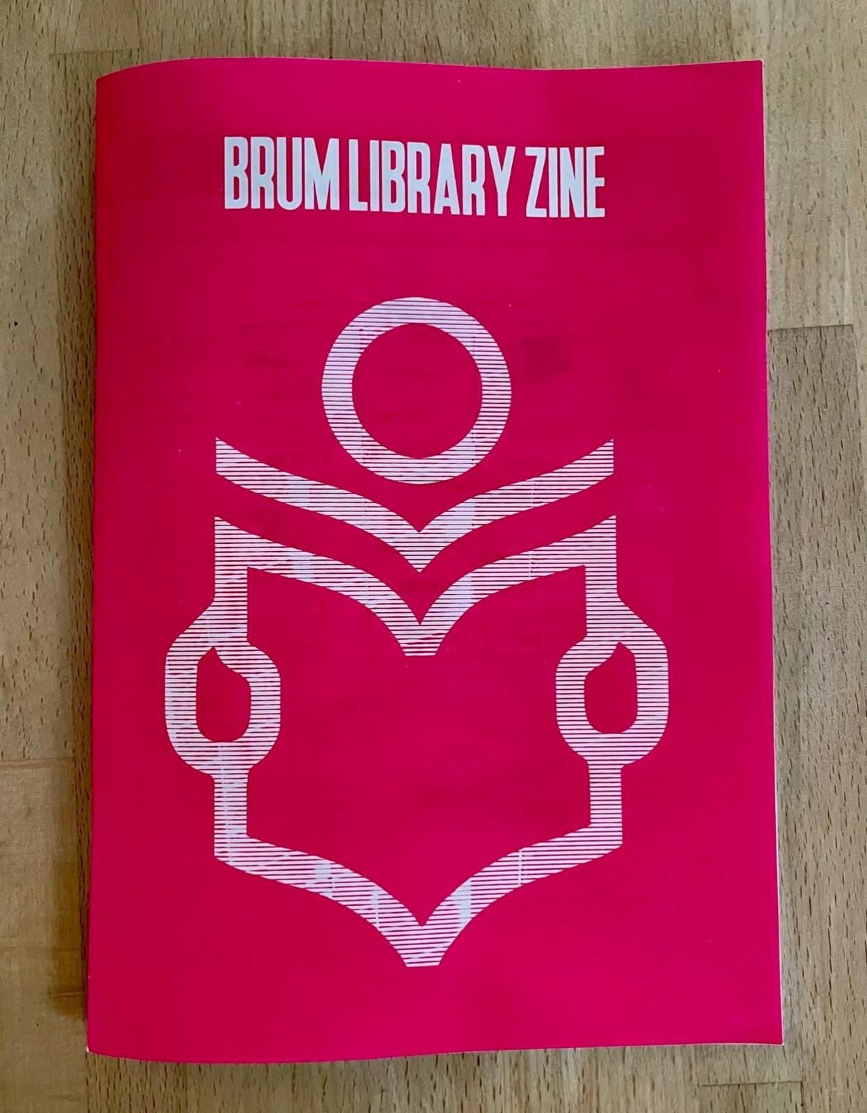 A pink magazine with the title "BRUM LIBRARY ZINE" in white capital letters. There is a large white icon on the cover that depicts someone reading a book.