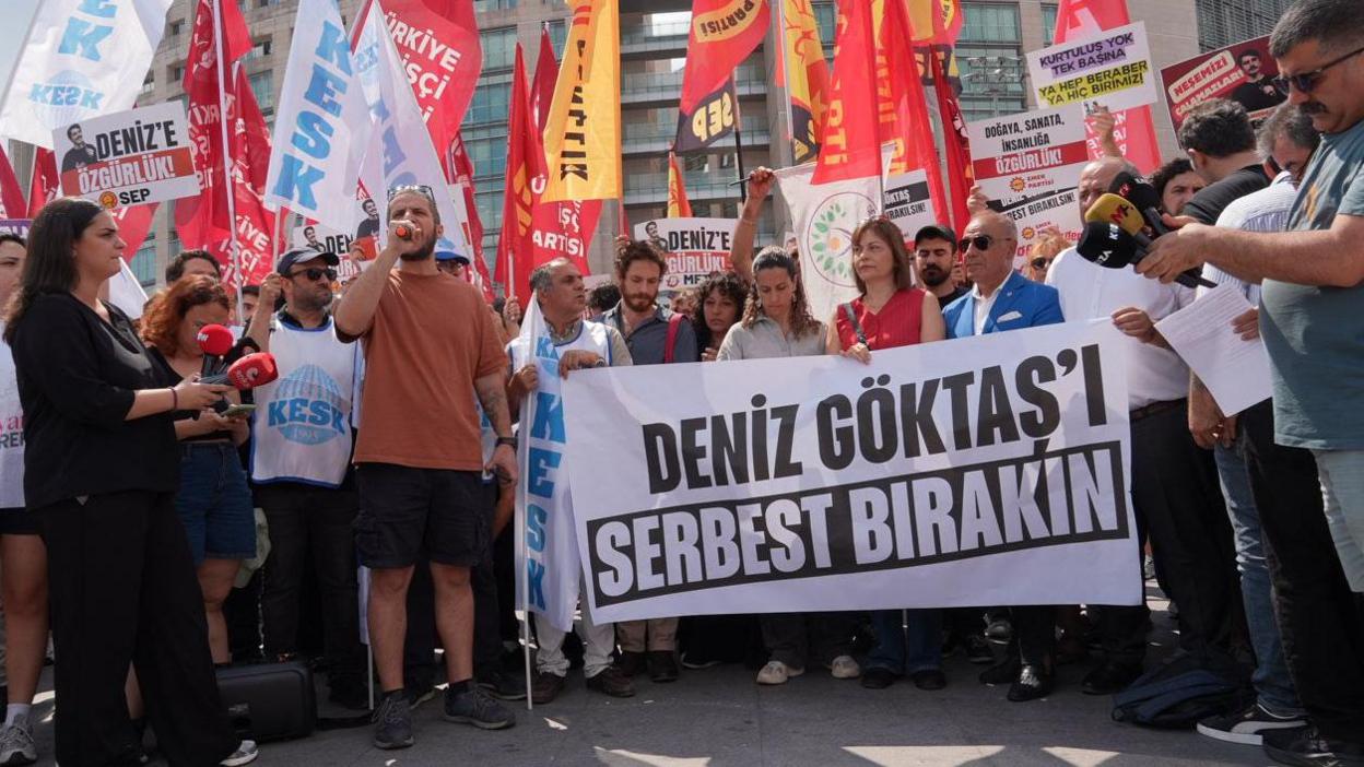 Men and women gather with placards in Turkish