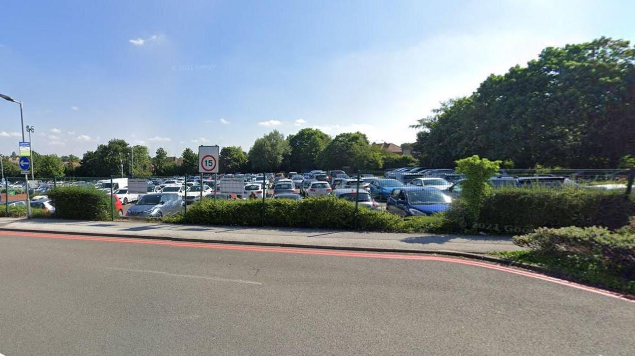 A photograph of the former car park six from the road - there are rows and rows of cars in there