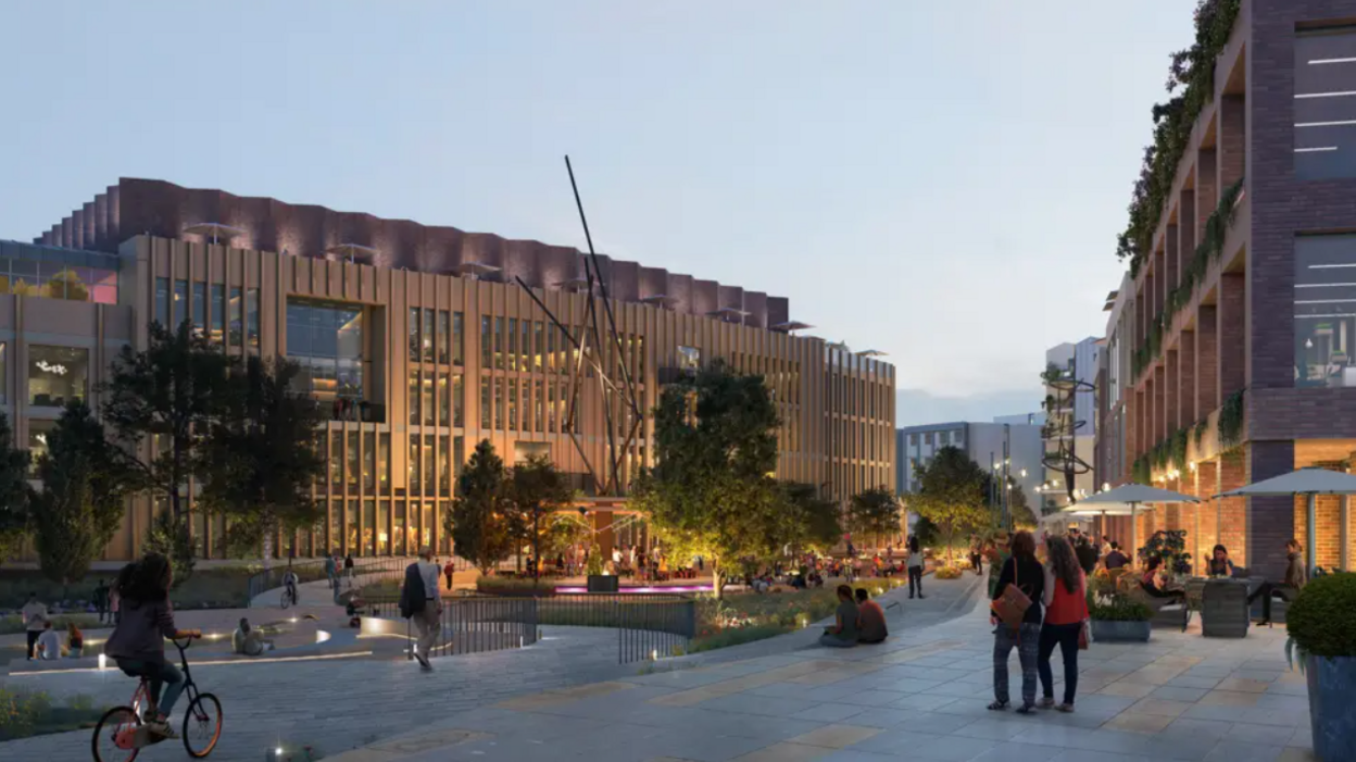 A computer-generated image showing what the new development could look like. It's a modern-looking square with smart buildings on either side. People are walking and cycling in the middle.