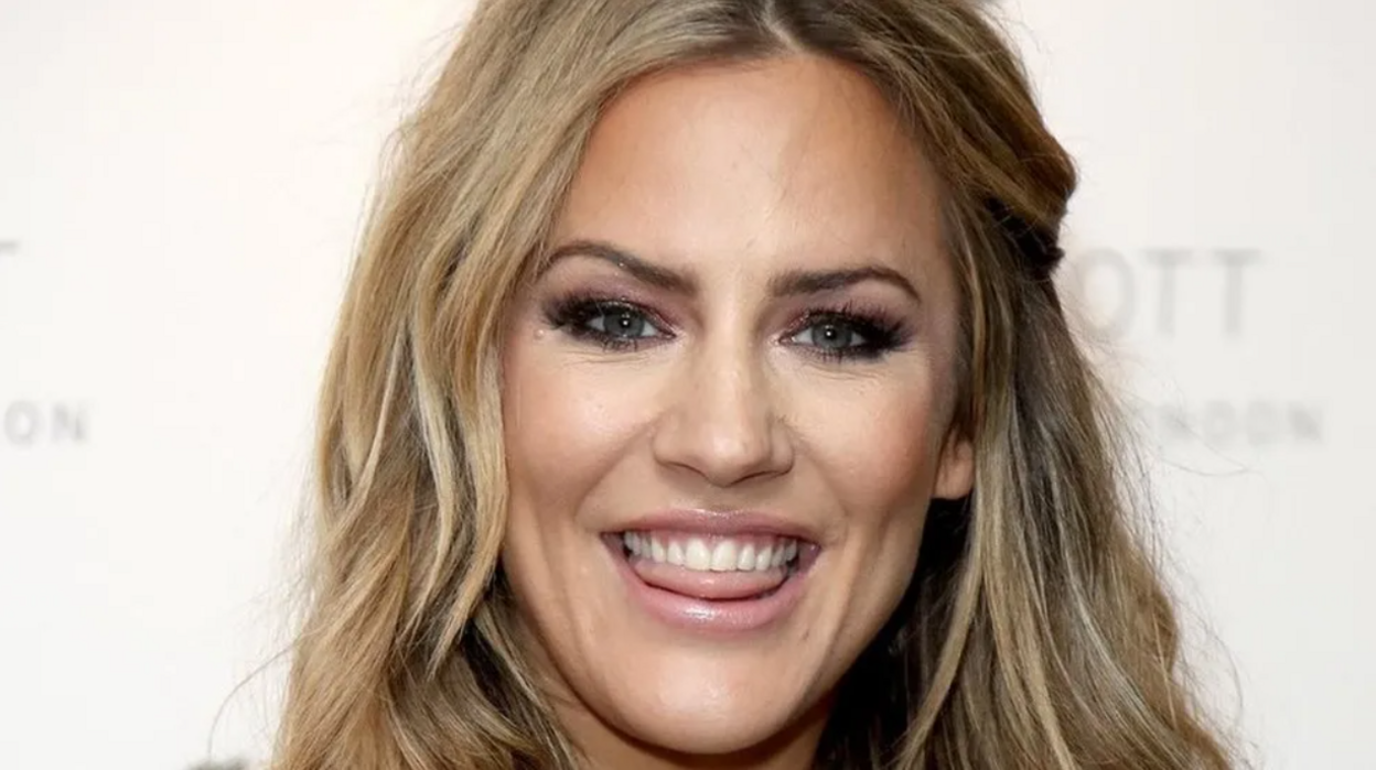 Caroline Flack from the chin upwards. She has long blonde hair and is smiling.