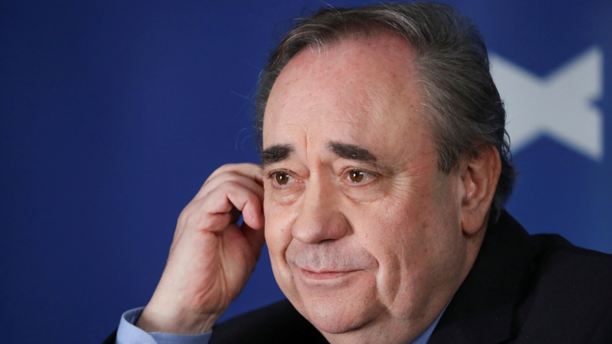 Alex Salmond with his right hand touching the side of his head