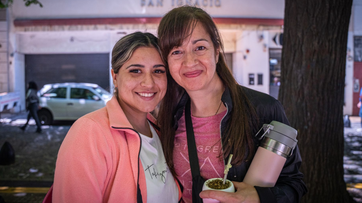 Argentinians Juliana and Veronica pose, facing the camera. Juliana wears a salmon pink fleece jacket and white t-shirt with her dark blonde hair tied back. Veronica wears a navy jacket and pink t-shirt with her long dark brown hair down.