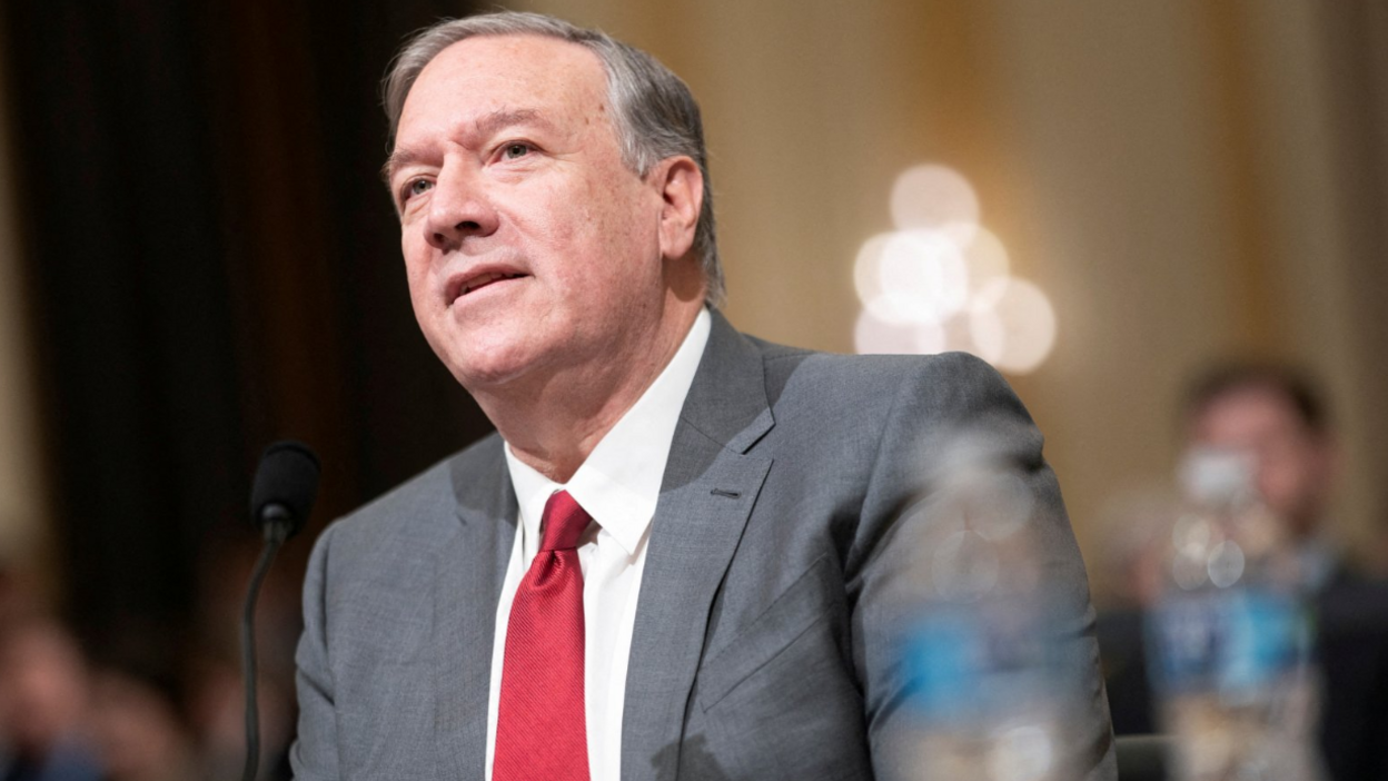 Mike Pompeo, who has neat grey hair brushed to the side, wears a grey suit, white shirt and red tie as he testifies before the House Select Committee in Washington