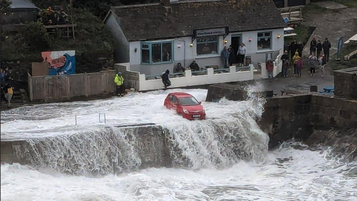 A car threatened by the waves at Porthleven