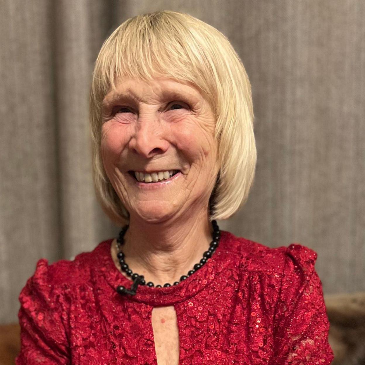 A woman in a glamorous red dress smiling