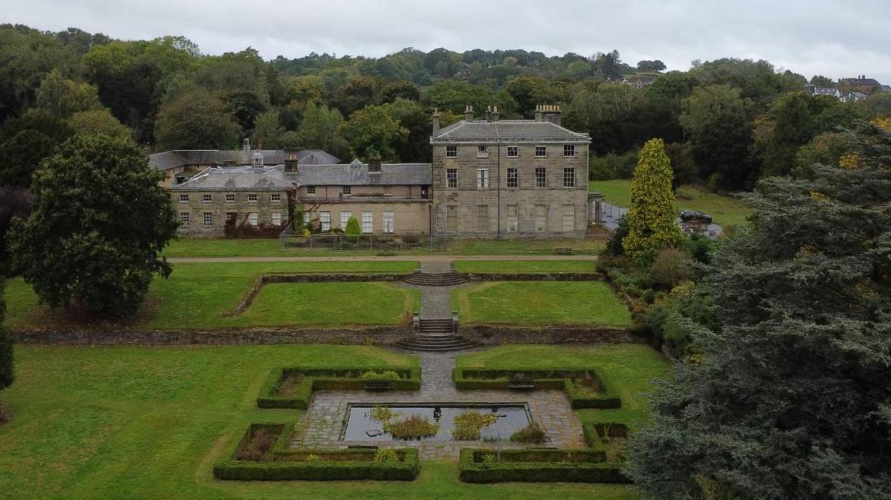 Drone view of the rolling front lawn and house 