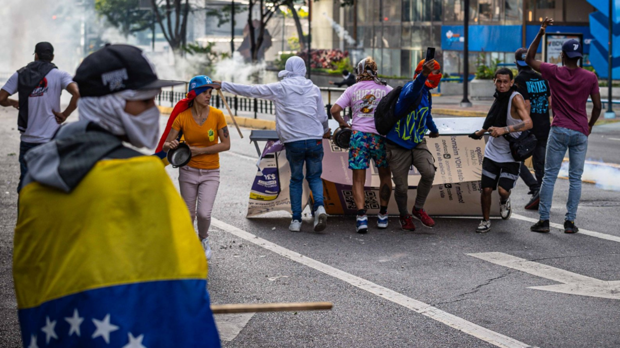 Riot police fired tear gas and rubber bullets at protesters in Caracas as thousands demonstrated against the outcome of Sunday's presidential poll