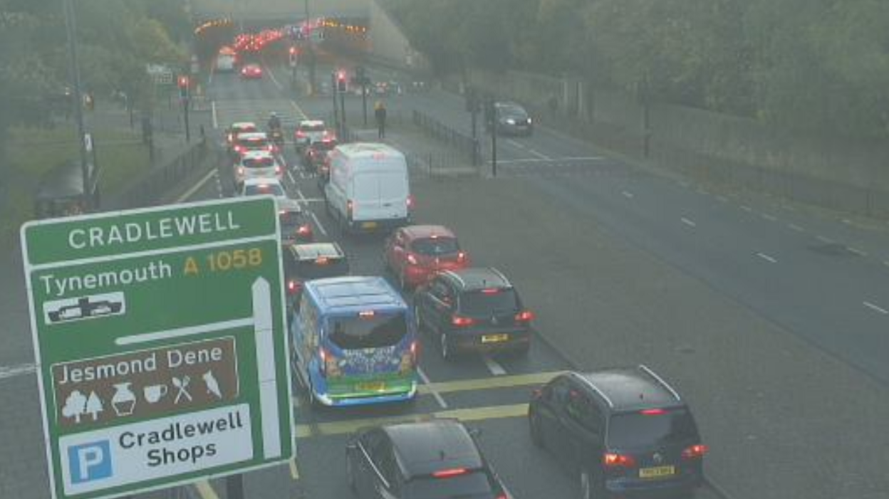 A queue of traffic next to a 'Cradlewell' road sign.