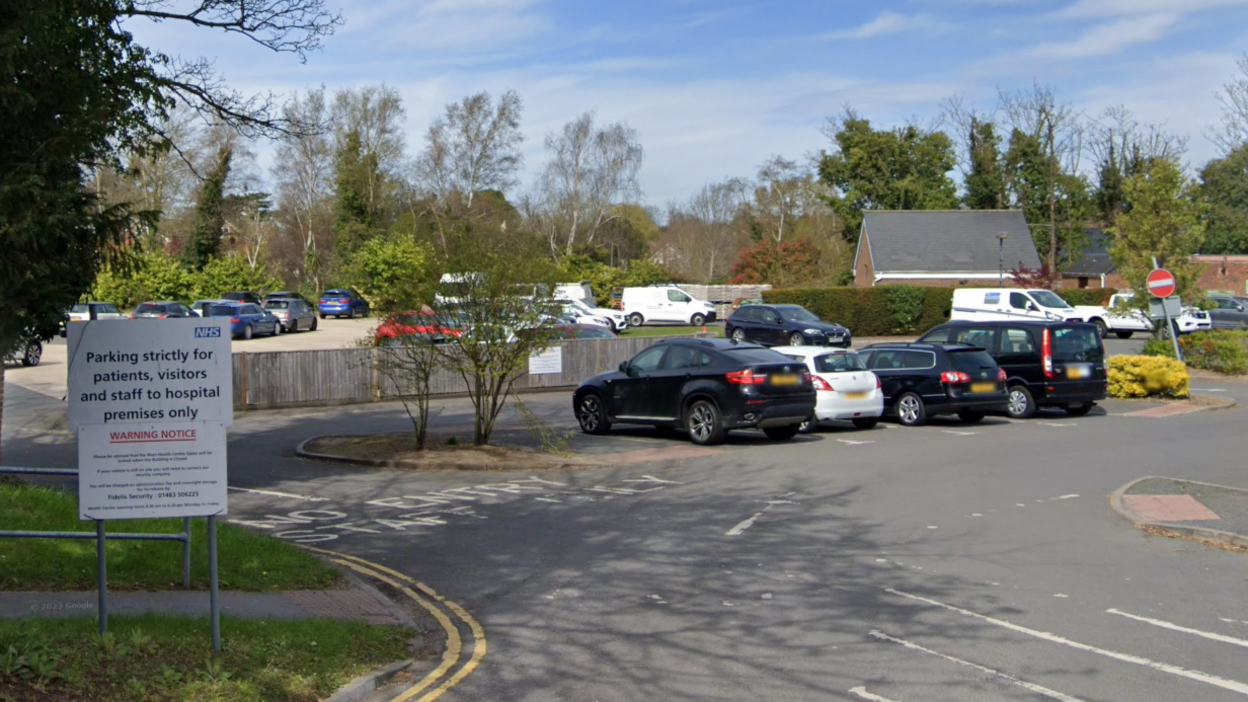 A Google street map image of the car park and land where the redevelopment could take place. It looks like an average car park with vehicles parked in it. There is an NHS sign to the left