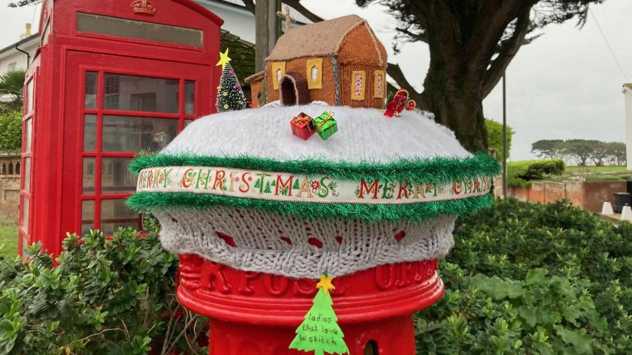 In Mudeford, Dorset, BBC Weather Watcher, Rainbow Watcher snapped this stunning postbox Christmas scene with knitted church, with snow on the ground and presents and tree topped with a star