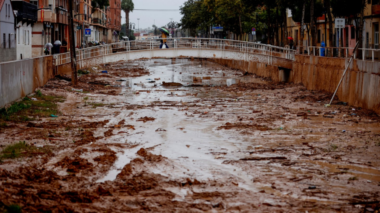 A person crosses the La Saleta ravine that recently overflowed due to heavy rainfall in Aldaia, Valencia