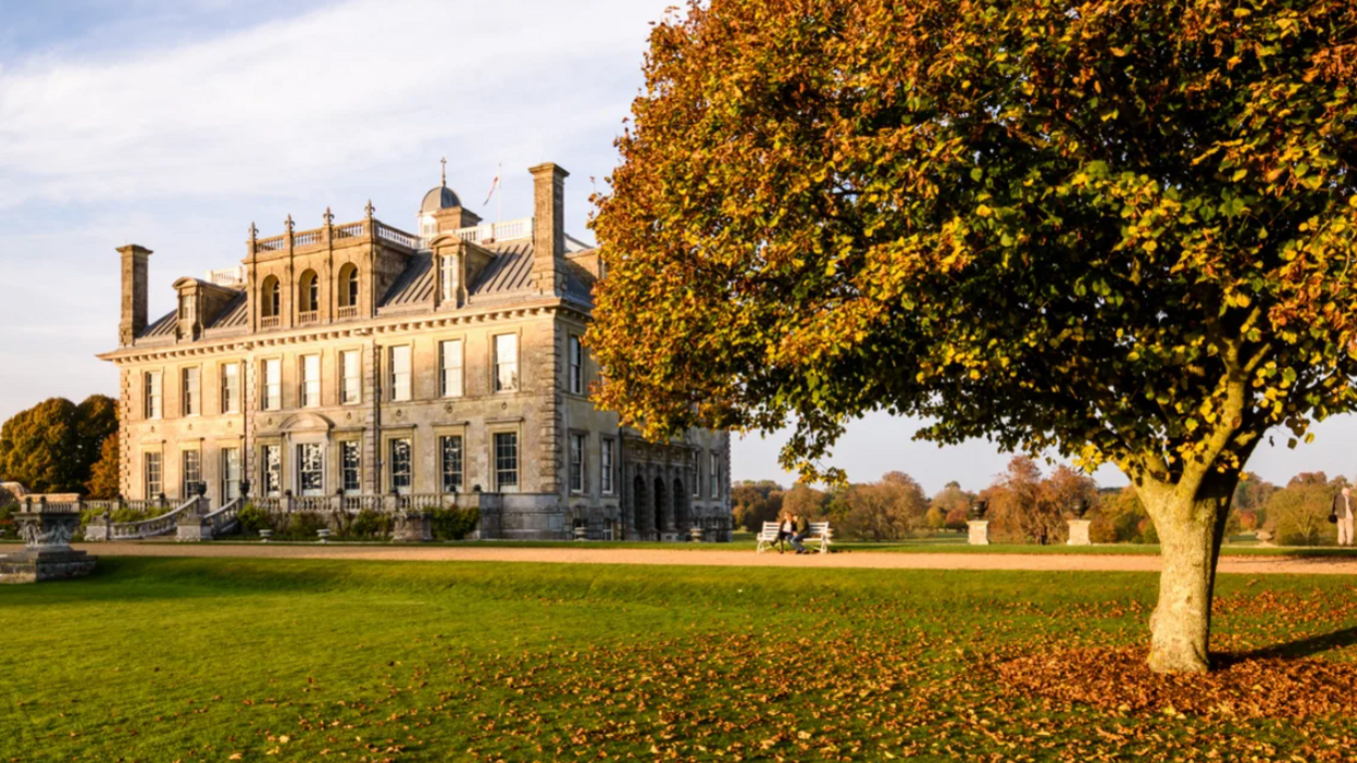 Kingston Lacy, a Venetian-style stately home. There is a tree in the foreground - the leaves are turning orange and falling in a pile below the tree