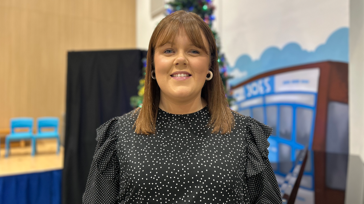 Gwen Shenton yn gwenu mewn ffrog polka dot du a gwyn