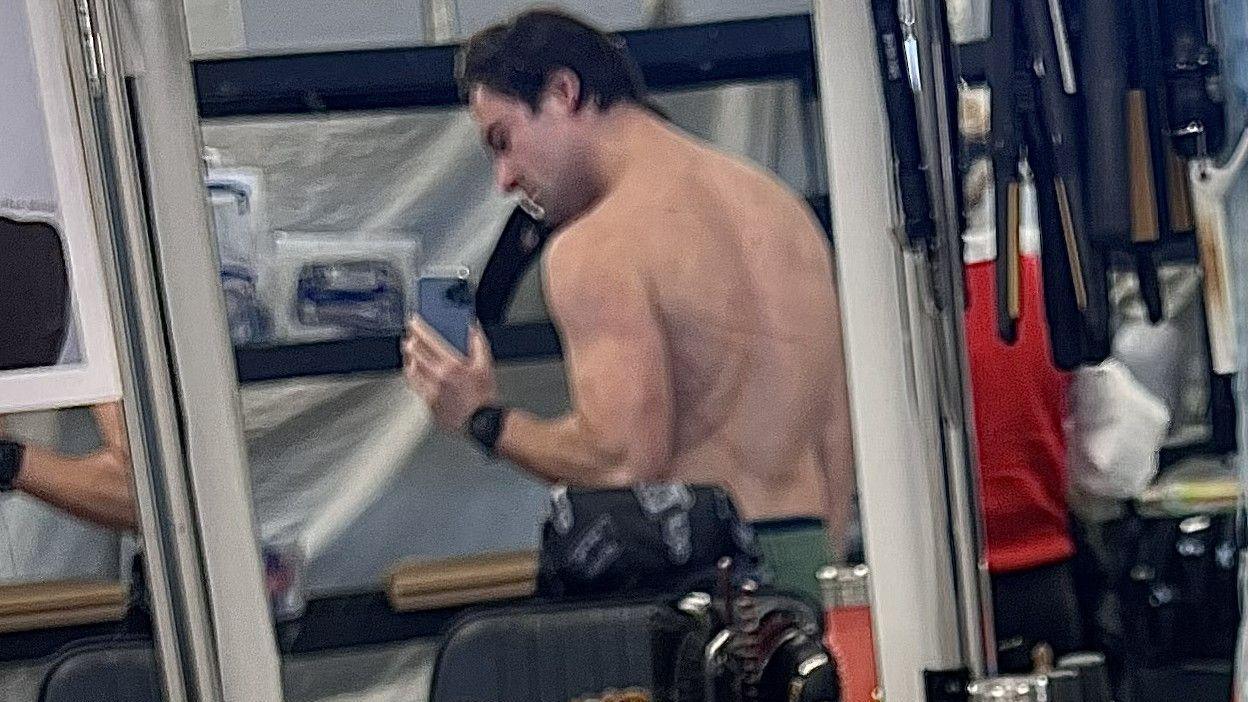 Bo Ponomari bën një foto të shpinës së tij në një pasqyrë. Në të mund të shihni shenja në shpinën e tij.