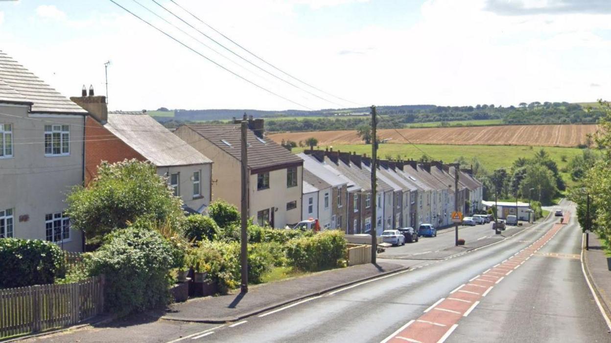 Houses line one side of Commercial Street in Cornsay Colliery, County Durham.