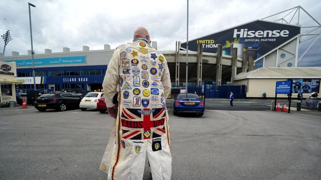 A Leeds United fan stands outside Elland Road