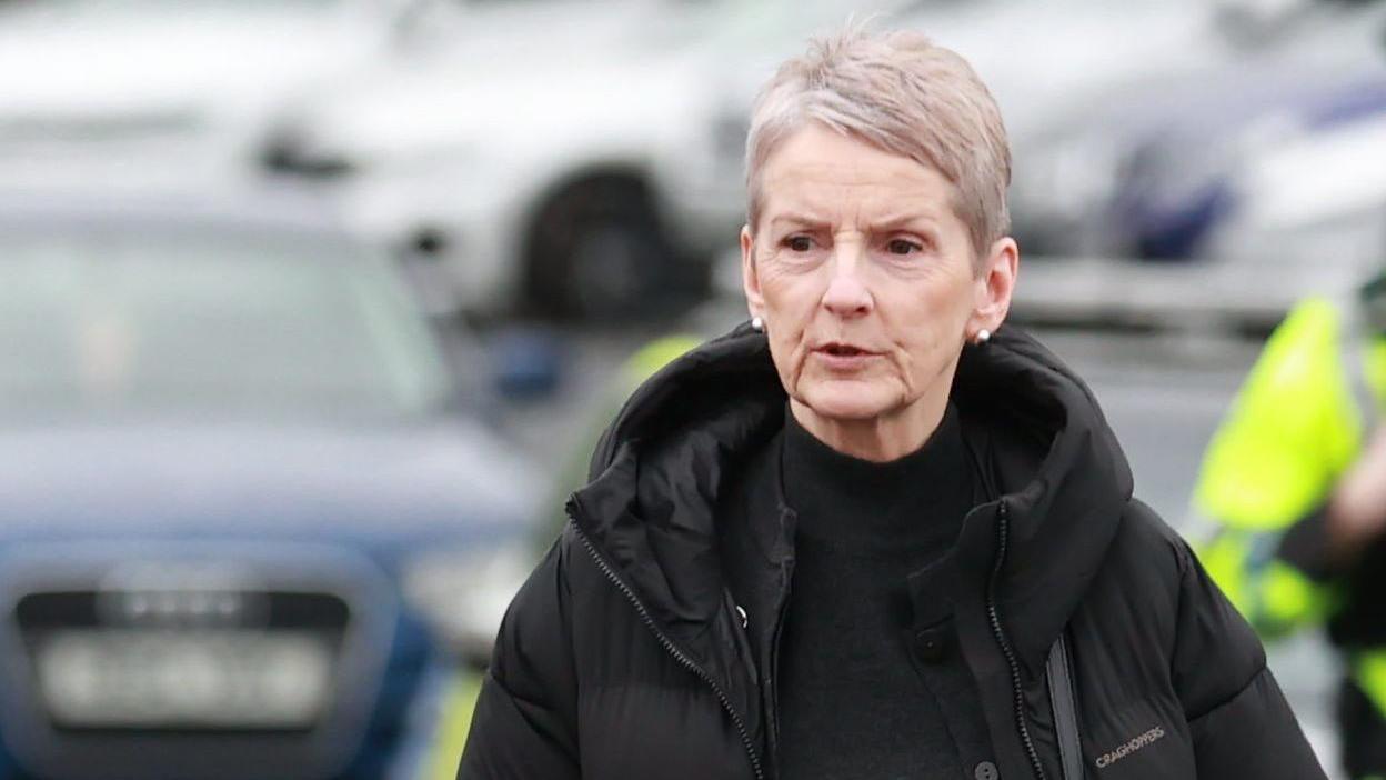 Lady Eleanor Donaldson, pictured with short grey hair, wearing a black top and a black coat.