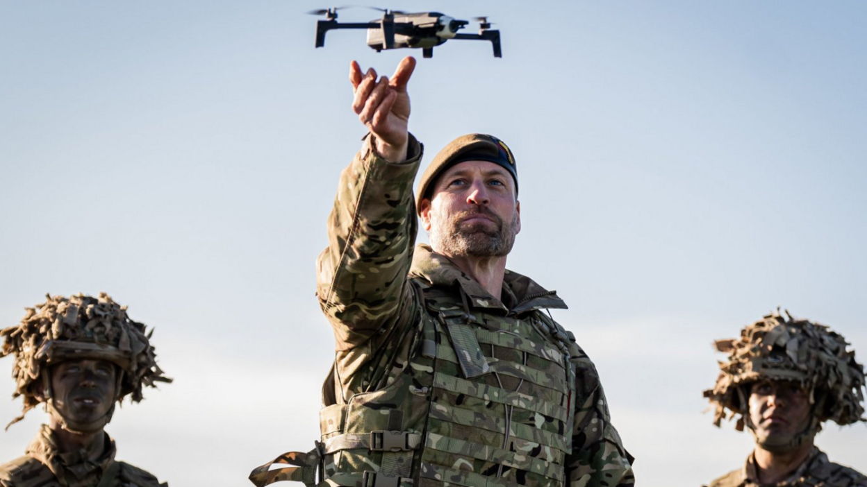 Prince of Wales in uniform of Colonel of the Welsh Guards, during a visit to the 1st Battalion Welsh Guards at Salisbury Plain - holding up a drone 