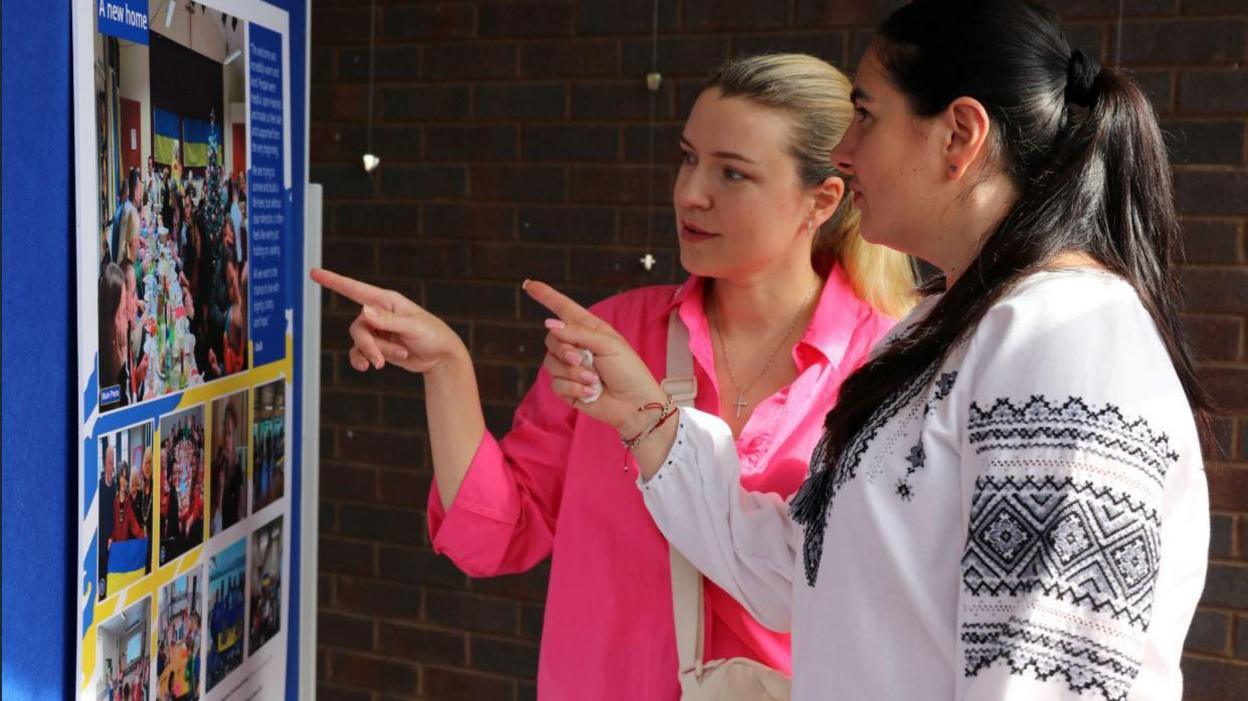 People examining the photographic exhibition in Northallerton Library