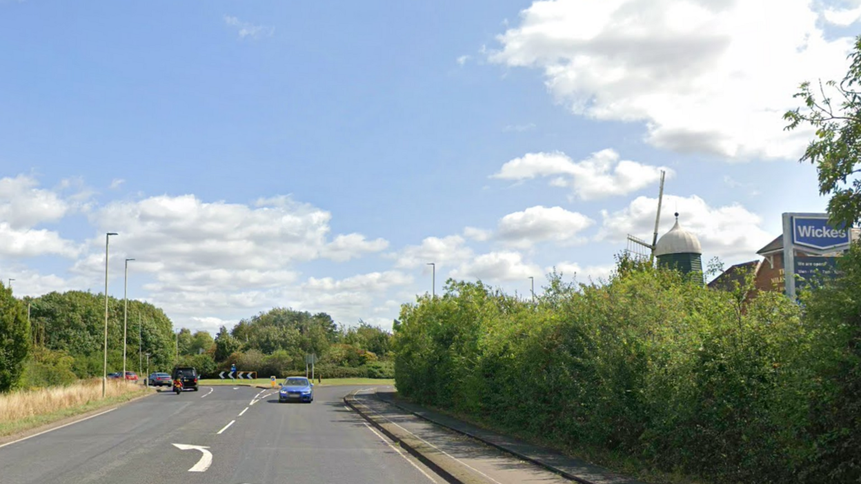 The perimeter road around Hinckley with the windmill of the Milestone pub peaking over a hedge