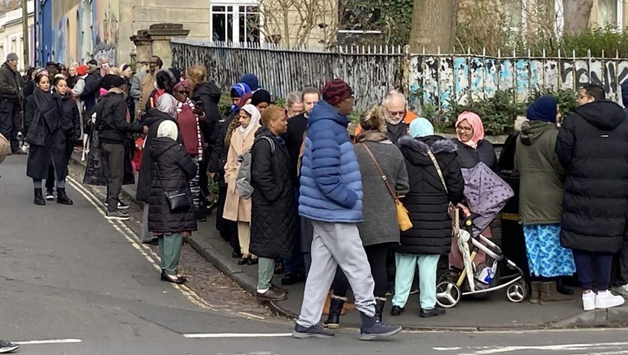 People standing in a queue waiting to register for an NHS dentist