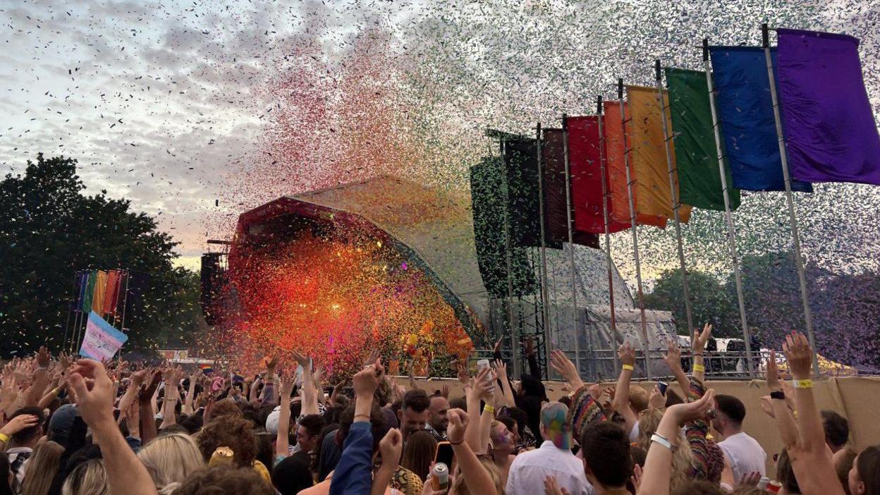 A Bristol Pride stage with hundreds of fans and multicoloured flags