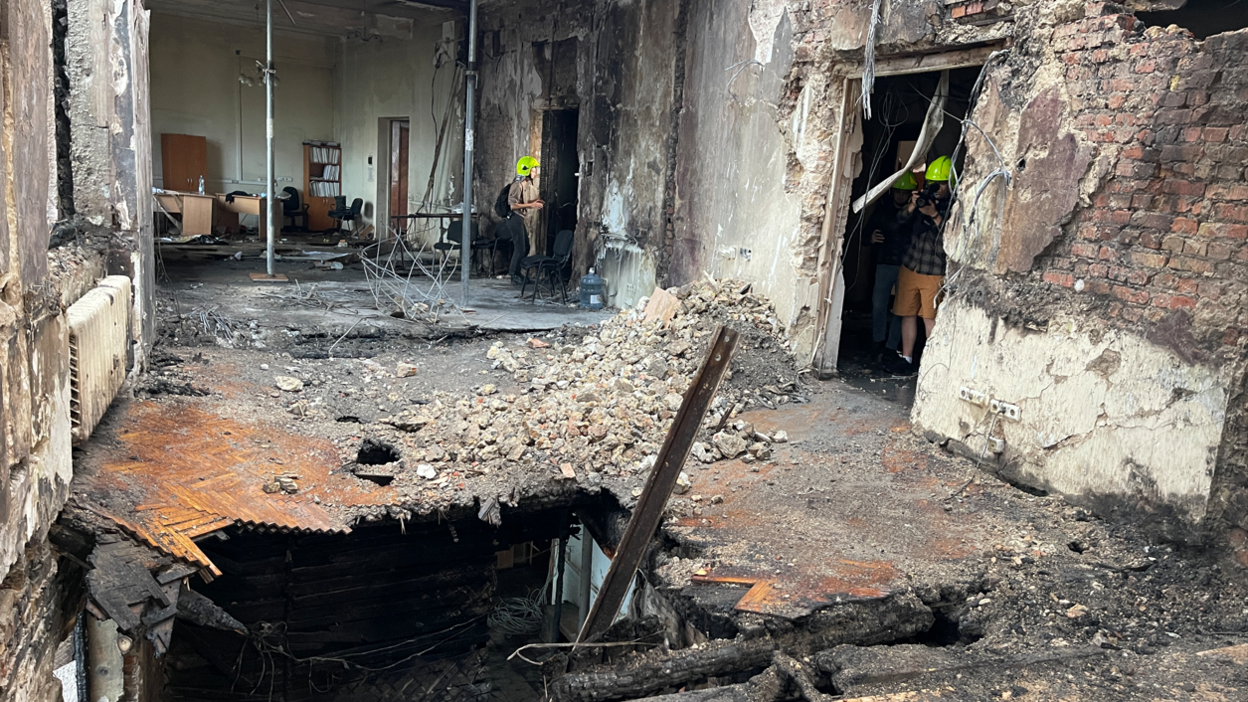 Journalists are shown the destroyed top floor of Ukraine's main government building in Kyiv, following a Russian air strike