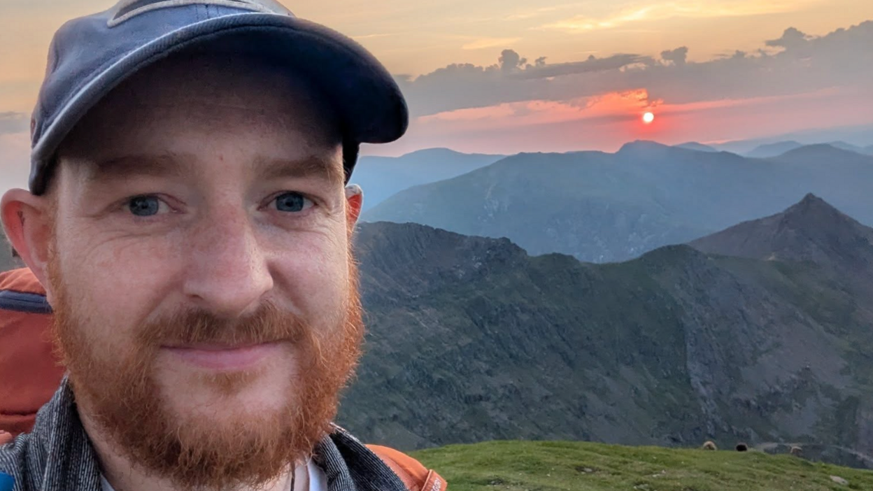 Llun Bryn Hughes ar ben mynydd
