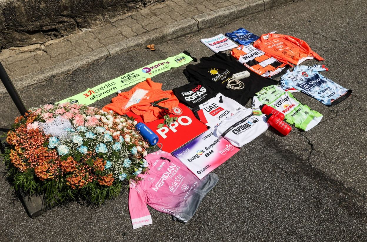 Cycling jerseys and bottles on the floor next to flowers