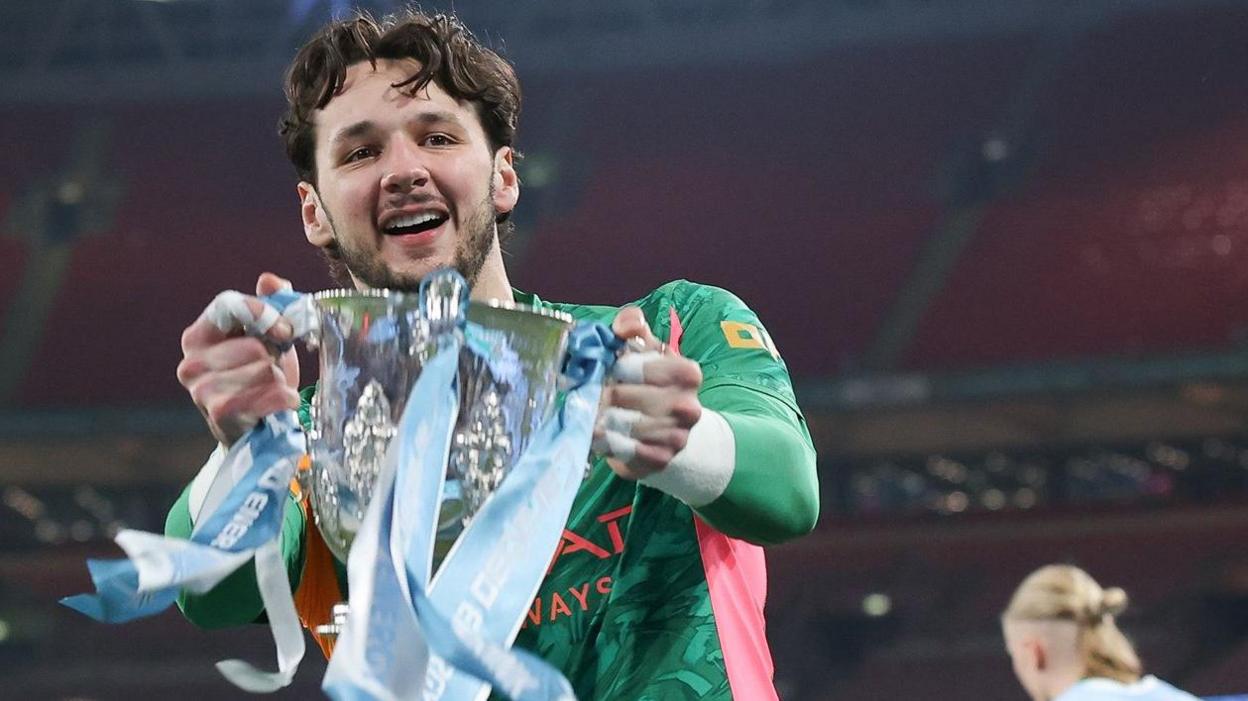 James Trafford holds the Carabao Cup trophy