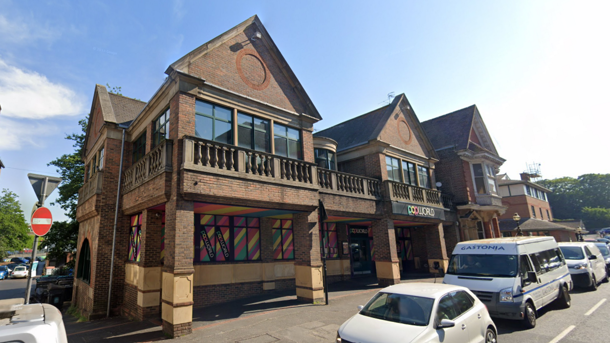 A building with multi-coloured window coverings and a sign reading "Popworld"