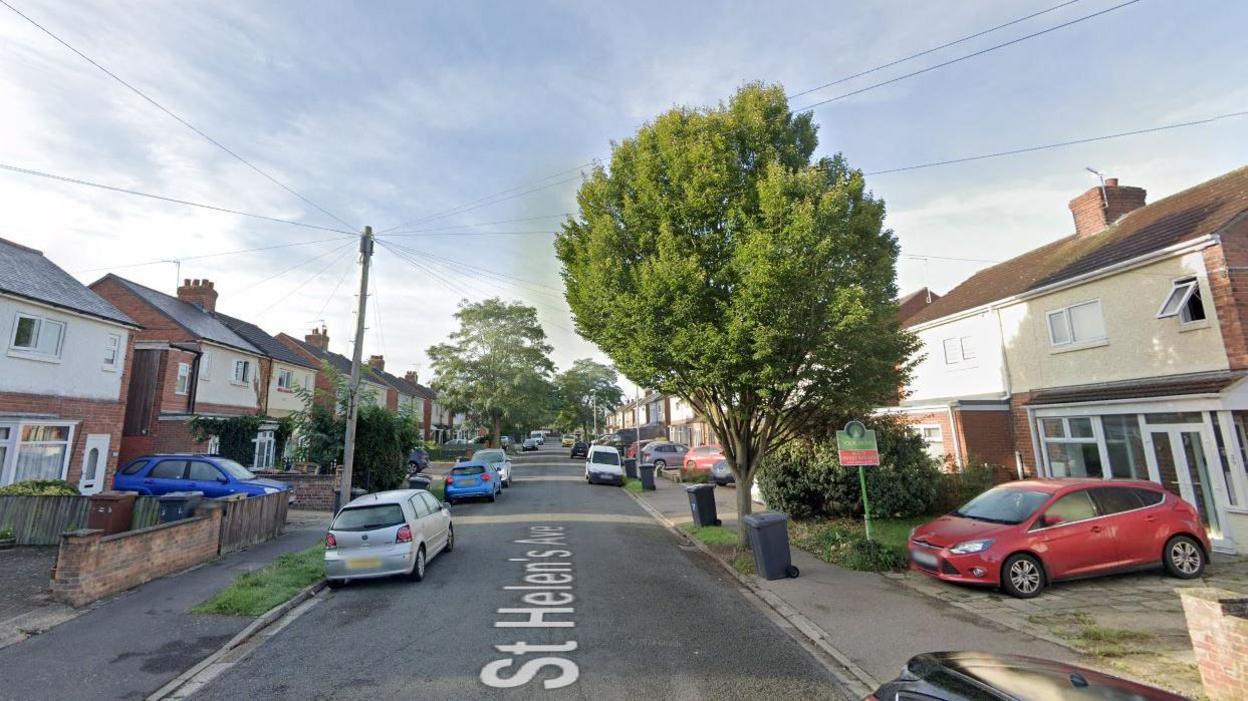 A Google Streetview of St Helen's Avenue. There are houses on both sides of the road. Cars are parked on the road and on drives