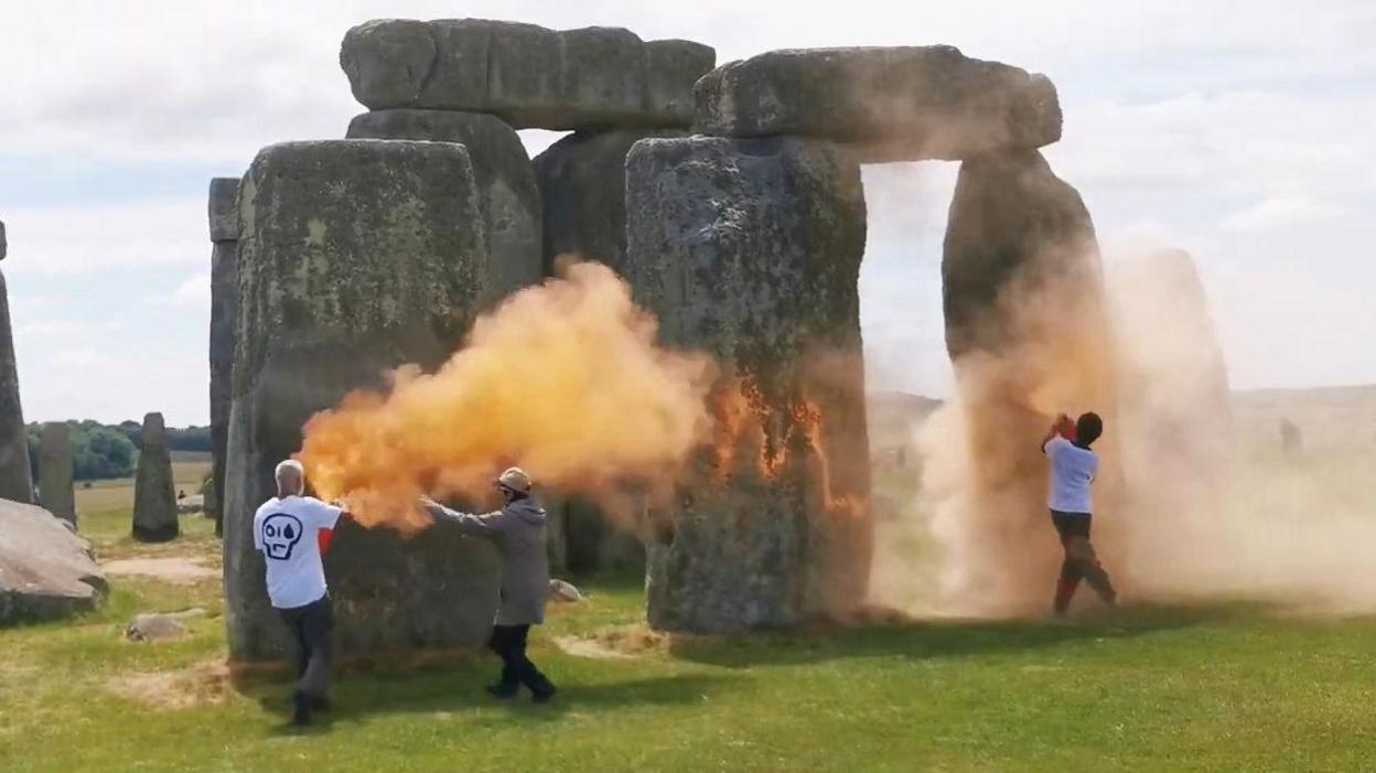 Orange clouds of paint being sprayed at Stonehenge