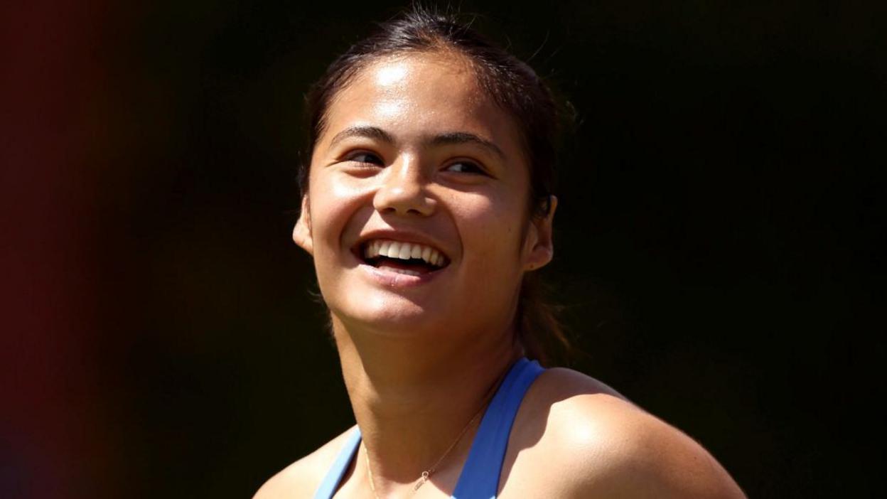 Emma Raducanu smiles after completing her opening victory at Queen's