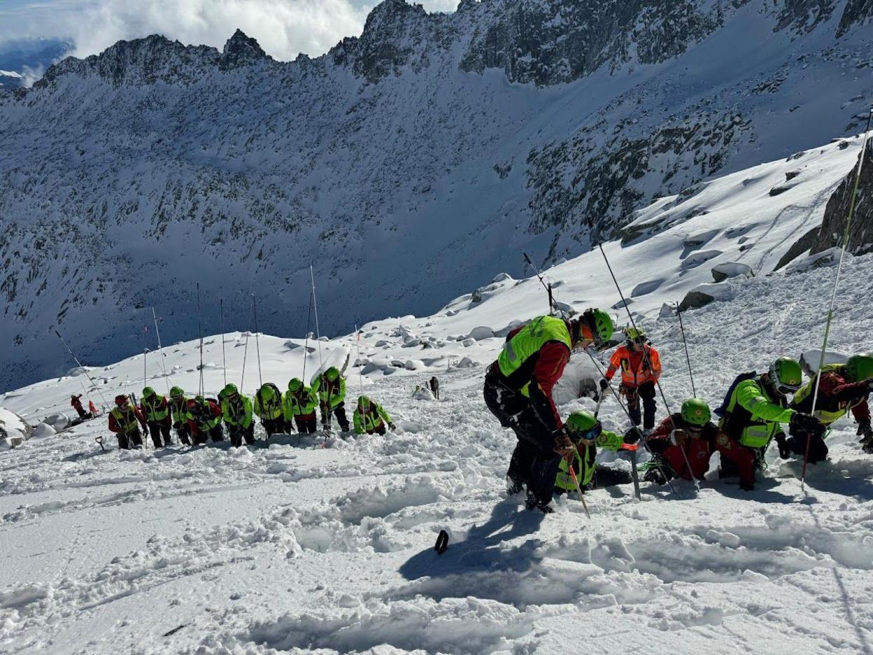 Rescuers on the mountain carry out a fingertip search on the snow