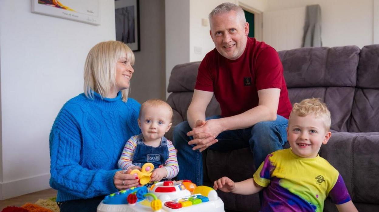 Family sitting in the lounge with toys in the foreground