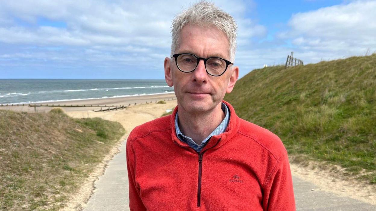 Japp Flikweert standing on a concrete ramp with the beach at Bacton gas terminal behind him