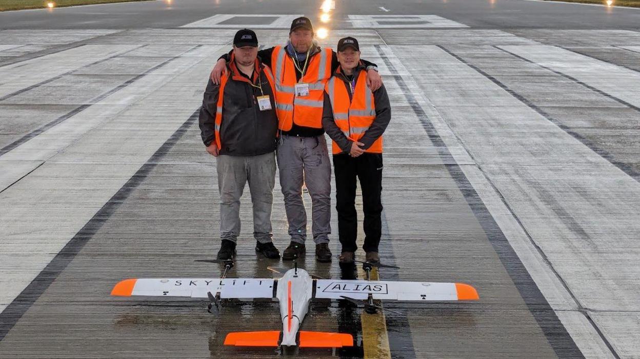 Three men and drone on runway