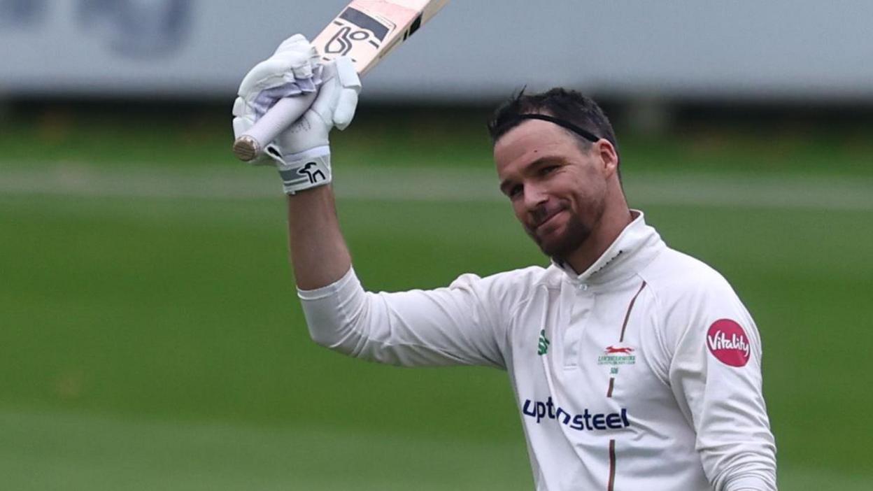 Peter Handscomb hold his bat up after scoring a century for Leicestershire