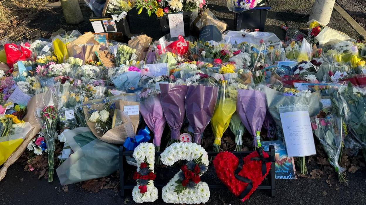 Dozens of flowers and tributes to Leo piled up near the scene of the incident. The number 12 is made out of flowers with a heart next to it with a black ribbon down its centre.