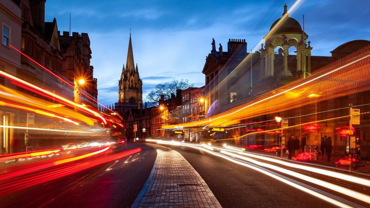 University Church of St Mary the Virgin in High Street, Oxford, and lights from vehicles streaming through the picture  