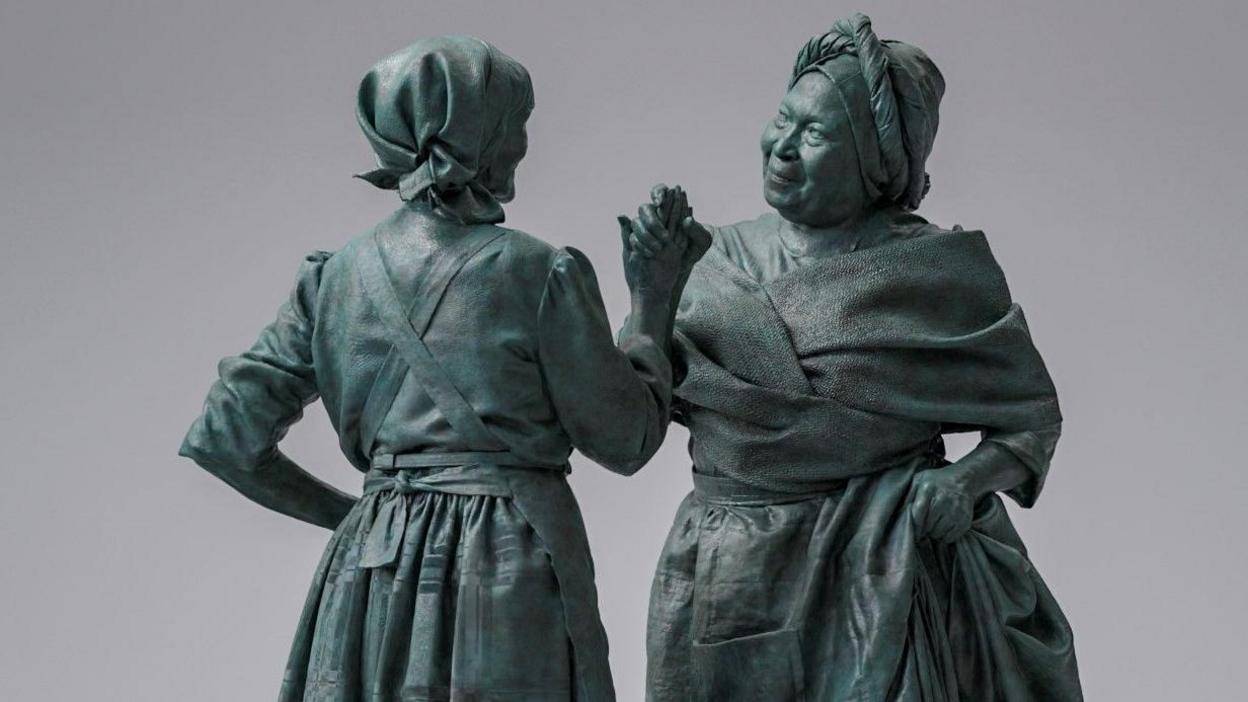 Statue design showing two women from the 19th Century clasping hands as they greet each other