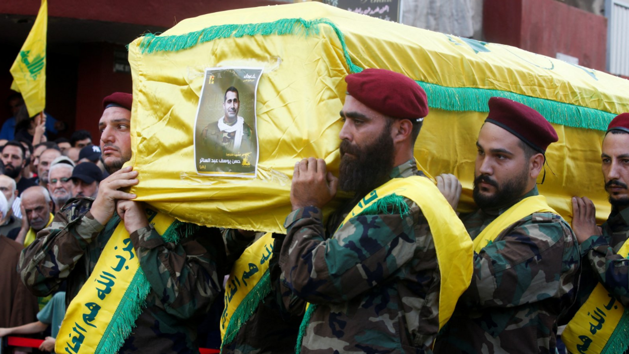 Hezbollah members carry the coffin, draped in yellow, of Hassan Youssef Abdel Sater who was killed on Friday in an Israeli strike on Beirut's southern suburbs