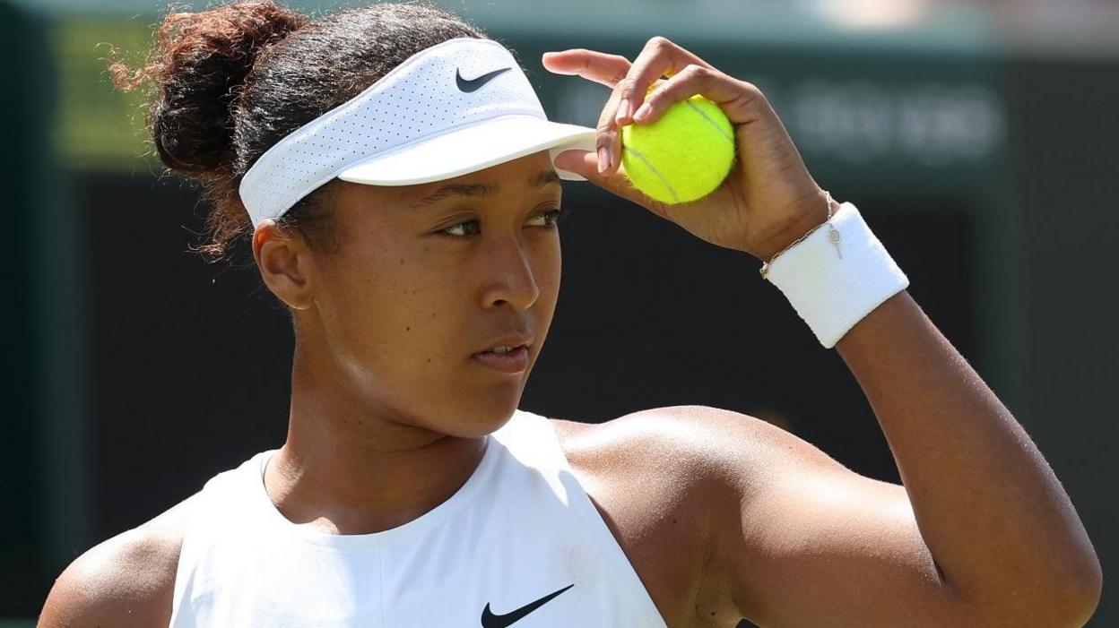 Naomi Osaka prepares to service during her Wimbledon third-round match